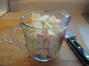 Diced paneer in a measuring cup